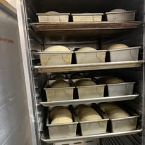 Homemade bread dough rising in baking pans at Bonnie's kitchen