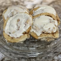 Close-up of four frosted cinnamon rolls at Bonnie's