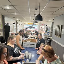 Packed diner with customers at counter and tables under pendant lights