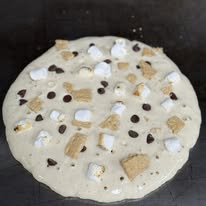 S'mores pancake cooking on the griddle with marshmallows and chocolate chips